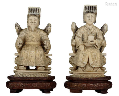 A pair of Chinese ivory figures with black ink decoration, depicting the Emperor and the Empress, first quarter of the 20thC, on an exotic hardwood base, H 12  - total height 15 cm - weight 550 gAdded expertise report according to CITES legislation. For European Community use only.