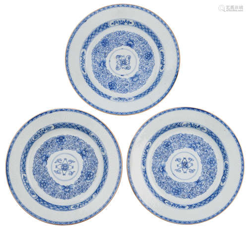 Three Chinese Kangxi period blue and white porcelain chargers with anhua design, the well decorated with a lily flower encircled by flower scrolls, the border with incised flower design and cloud scrolls, the rim with brown glaze, 18thC, ø 38 cm