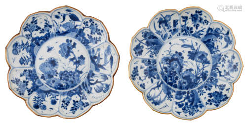 Two Chinese Kangxi period blue and white lotus-shaped dishes, the central roundel decorated with a flower garden, depicting the four seasons, surrounded by petal-shaped panels, variously painted with ditto design, marked with 'yu', ø 22,5 cm     