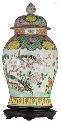 An imposing Chinese famille rose vase and cover, decorated with phoenix in a garden setting, the cover and shoulder with lotus flowers, antiquities and ice-cracking pattern, on a matching hardwood stand, H 68,5 (without stand) - 76,5 cm (with stand)