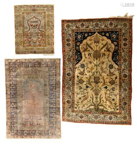 An Oriental rug in wool and silk with birds and floral motifs, 140 x 211 cm; added: an Oriental silk prayer rug , 117 x 165 cm; extra added: an Oriental silk rug, signed to the centre, 84 x 115 cm