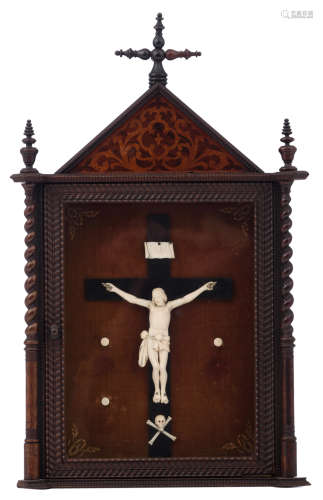 A carved ivory Corpus Christi mounted on an ebonized wooden cross, the whole presented in a rosewood and burl wood veneered and with velvet upholstered case, early 20thC, the case: H 56,5 - W 35, the Corpus: H 14 - W 15 cmAdded expertise report according to CITES legislation. For European Community use only.