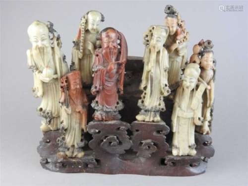 A Chinese carved soapstone group of the eight immortals, each figure modelled separately in red