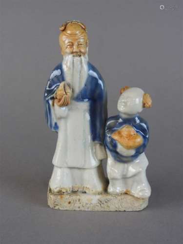 A Chinese partially glazed biscuit porcelain figure of Shou Lao and attendant boy, Qing dynasty,