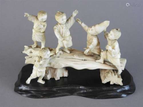 A Japanese carved sectional ivory group of five children playing on a log plank, Meiji period (