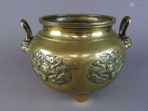 A Chinese brass two handled censer, late Qing dynasty, the bulbous body cast with four panels of