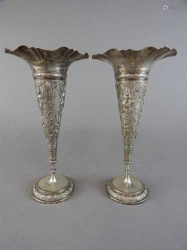 A pair of white metal vases