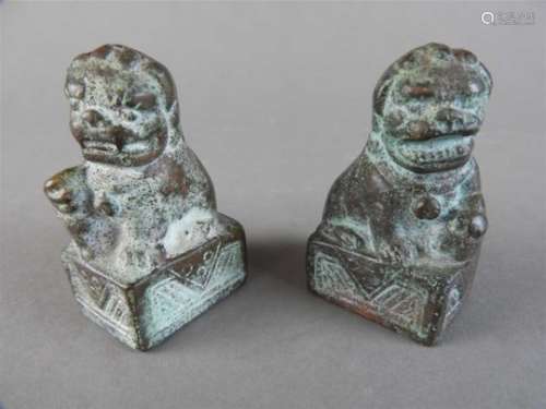 A small pair of Chinese bronze lion dogs, 19/20 th century, each recumbent animal facing the