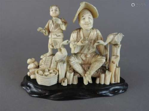 A Japanese carved sectional ivory cormorant fisherman and attendant, Meiji period (1868-1912),