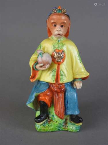 A Chinese polychrome porcelain figure of a monkey dressed as the god of good fortune holding a