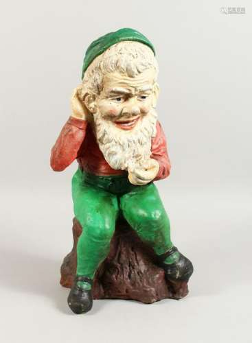 A PAINTED CAST COMPOSITE SEATED GNOME.  19ins high.