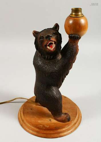 A BLACK FOREST AND CARVED WOOD STANDING BEAR LAMP, on a