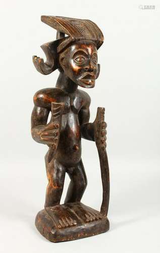 A CARVED WOOD TRIBAL STANDING FIGURE, of a man with