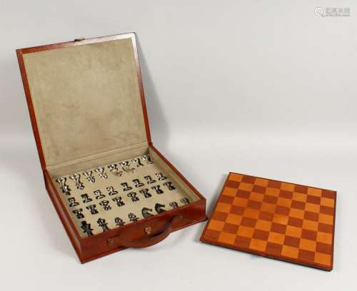 A GOOD LEATHER CASED CHESS SET.  13ins wide.