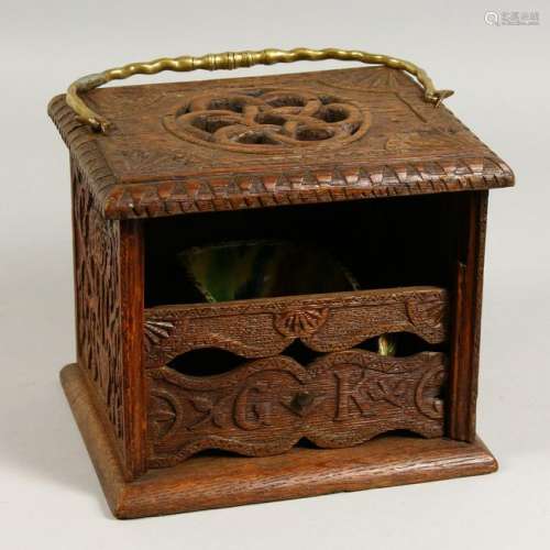 A 19TH CENTURY OAK BOX, with brass handle, carved with