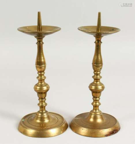 A PAIR OF EARLY BRASS CANDLESTICKS, with broad drip