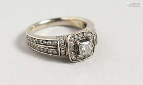 A 14CT WHITE GOLD RING, the central diamond surrounded