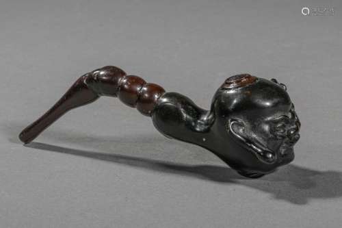 JAPON, XIXe siècle. Pipe en bois sculptée d'un têt…