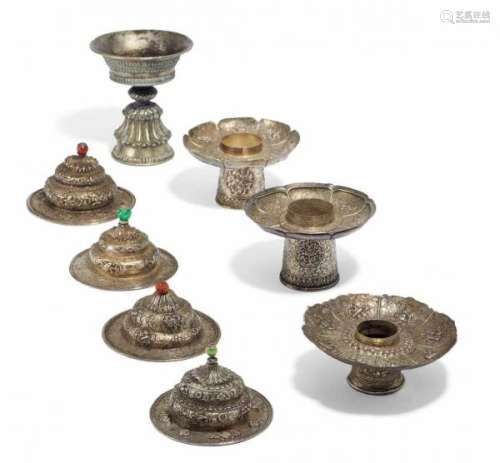 ONE BUTTER LAMP, THREE BASES AND FOUR LIDS FOR TEA BOWLS. Tibet. 19th/20th c. Silver [...]