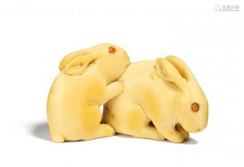 NETSUKE: TWO LITTLE RABBITS. Japan. 19th c. Ivory, eyes inlaid with coral. Width [...]