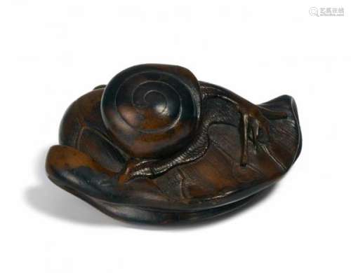 NETSUKE: CLOSED LOTUS LEAF WITH SNAIL. Japan. Edo period. 18th c. Kaki wood. Width 4.5cm.