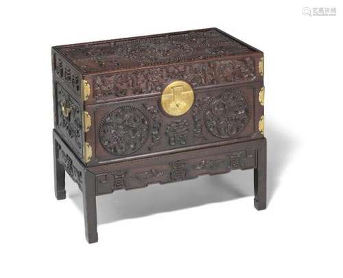 A Chinese richly carved  hardwood chest with brass mountings and carrying handles. [...]