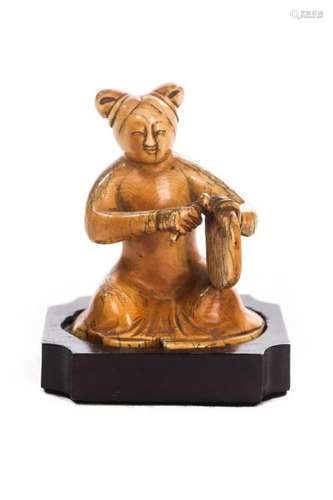 Statuette en ivoire représentant une musicienne jouant d'un instrument à percussion [...]