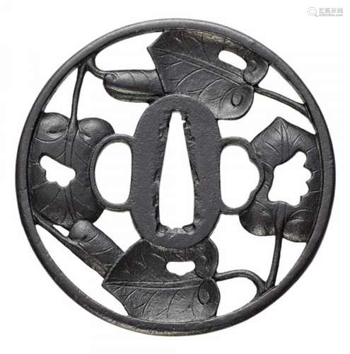 An Echizen iron tsuba. Edo periodOf round shape with aoi leaves in openwork. Wooden [...]