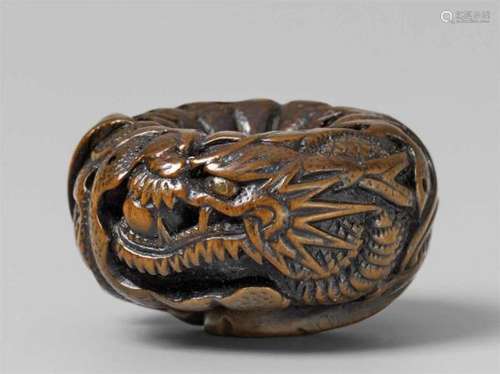 A fine boxwood netsuke of a dragon in a mikan. Boxwood. Mid-19th centuryThe scaly [...]