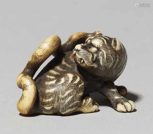 An ivory netsuke of a tiger. First half 19th centurySeated with forelegs wide apart, [...]