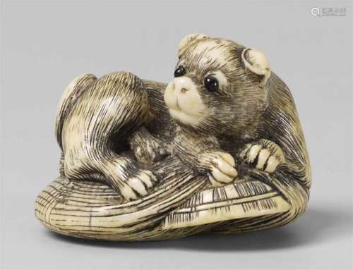 An ivory netsuke of a dog. Early 19th centuryLying on a rain cape (mino) and a straw [...]