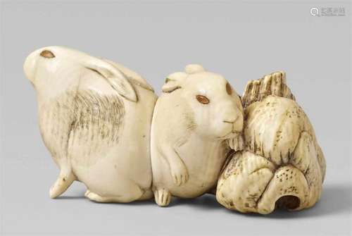 A fine ivory netsuke of two hares next to a rock. 19th centurySitting closely [...]