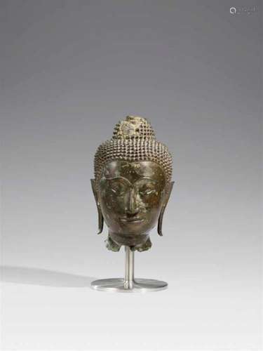 A Sukhothai bronze head of Buddha. 15th centuryWith an elegant face tapering toward [...]