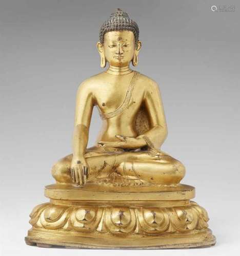 A Tibetan gilt bronze figure of Buddha Shakyamuni. 18th centurySeated with a serene [...]