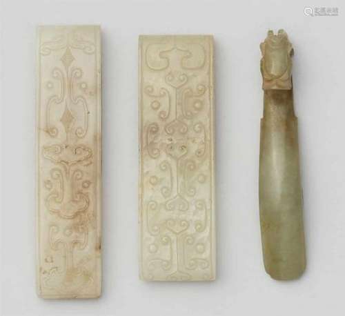 Two seladon-coloured scabbard slides and a jade belt hook. Han dynasty or latera) and [...]