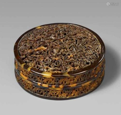 A round tortoiseshell box. 19th centuryThe slightly domed lid carved in openwork with [...]