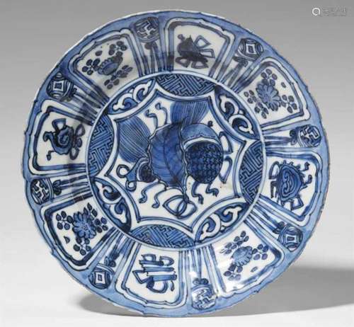 A blue and white Kraak dish. 17th centuryWith everted foliated rim, decorated to the [...]