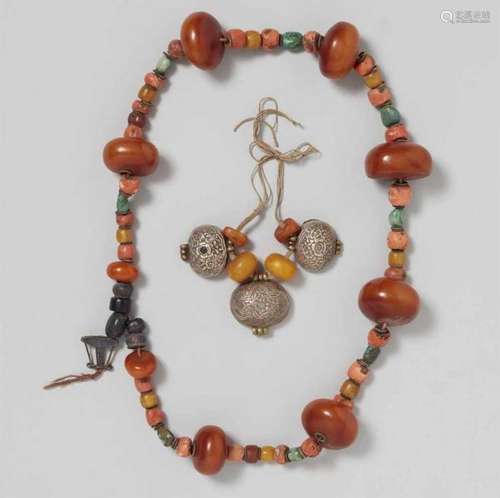 A Nepalese necklace and braceleta) With large beads of amber and at intervals by [...]