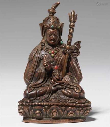 A Tibetan bronze figure of Padmasambhava. 18th/19th centurySeated in vajrasana on a [...]