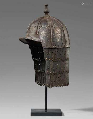 A Tibeto-Chinese military metal-inlaid iron helmetThe domed helmet, riveted into nine [...]