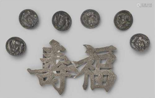 A silver two-part belt buckle and sic silver buttons. Late 19th centurya) In shape of [...]