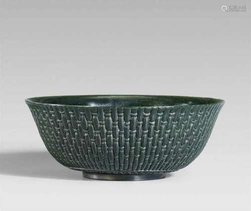 A dark green jade bowlA dark green jade bowl carved in low relief with a basket weave [...]