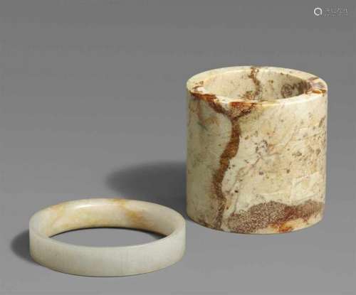 A jade ring and a stone cylindera) With meander pattern in very fine incisions, b) [...]