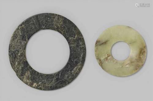 Two discsa) Of black marbled stone, the rims rounded, chips to the rims, and b) of [...]