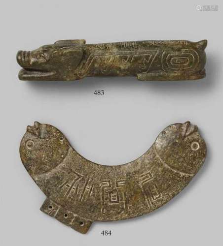 A brownish mottled stone figure of a recumbent pigOf long shape with a stylised head [...]