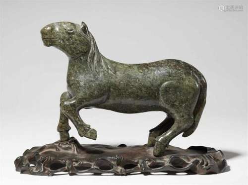 A dark green mottled stone figure of a horseStanding with left foreleg raised. Wooden [...]