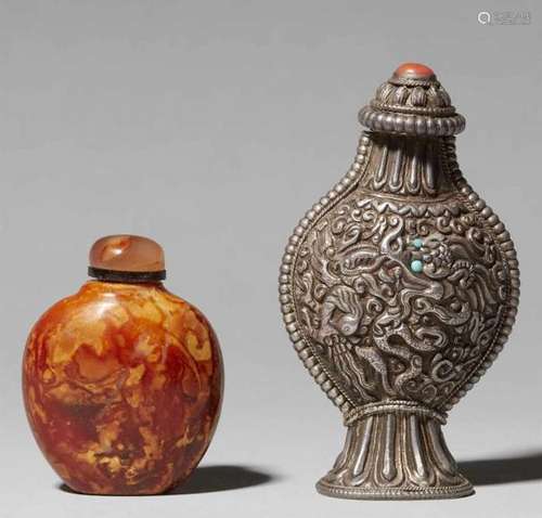 Two snuff bottlesa) Of round shape of cloudy, honey-coloured amber, and b) silver, [...]