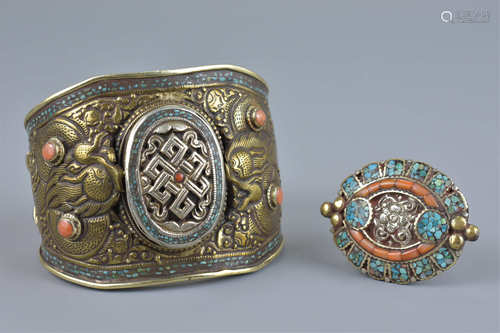 A large Tibetan metal bangle with coral coloured stones decorated with two dragons and incised decor