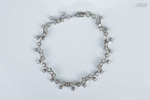 A white metal and diamond linked bracelet