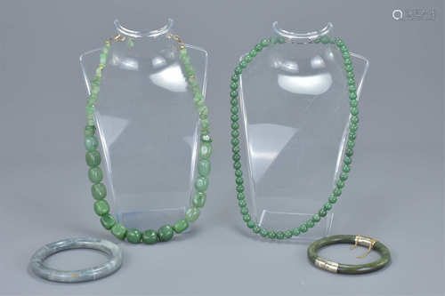 Two jade bead necklaces together with a jade bangle with white metal clasps with one other bangle. (